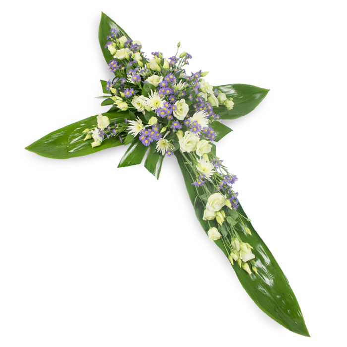 This heartfelt cross arrangement, seen from a slight overhead perspective against a plain white backdrop, combines bold structural foliage with tender, pale blooms to create a composed, spiritual tribute. The foundation is a skein of large, glossy green tropical leaves - their waxy texture and pronounced veins arranged to define the cross's arms with a sense of permanence and shelter. At the core and extending along the beam of the cross are soft clusters of lisianthus in creamy ivory and white, blossoms with delicate, layered petals that suggest both purity and gentle mourning. Interwoven among them are small, rounded white chrysanthemum heads that add concentrated brightness and refined texture, while sprigs of tiny lavender or pale purple limonium/asters provide subtle punctuation and depth, like a quiet musical cadence through the flowers. Fine green filler foliage is tucked through the clusters, softening edges and enhancing a feeling of organic grace. The lighting is even and respectful, highlighting the leaves' sheen and the petals' soft translucence; one can almost sense a faint, green-tinged scent and the serenity of a quiet chapel or a morning ceremony near local landmarks such as Hornchurch High Street or Harrow Lodge Park. Intended for funeral services, memorials or church tributes in and around Emerson Park, this cross expresses compassion, faith and a calm hope that resonates with families seeking a traditional, comforting emblem of remembrance.